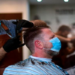 A hairdresser wears a face mask as he cuts a customer's hair in Dortmund, Germany, on Monday.