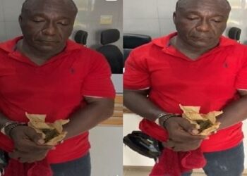 Apostle Kwabena Owusu Agyei holding the substance suspected to be marijuana
