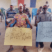 Some NPP members holding a placard with the inscription 'Party structures must work'