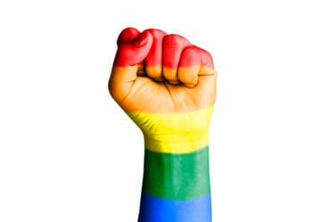 Fist hand with rainbow flag patterned isolate on white - Homosexual, gay and love concept