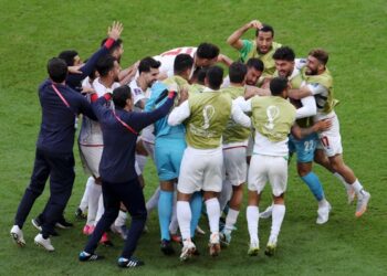 Iran celebrate their dramatic late win over 10-man Wales
