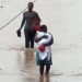 The woman carried her baby through the flood